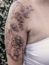 Tatouage de vignes avec grappes et fleurs sur l'épaule